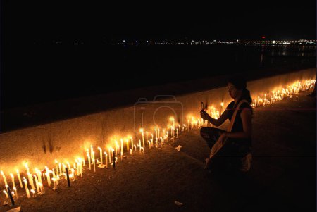 Photo for People lighting candles at marine drive paying homage to victims of terrorist attack by deccan mujahedeen ; Bombay Mumbai ; Maharashtra ; India 30-November-2008 - Royalty Free Image