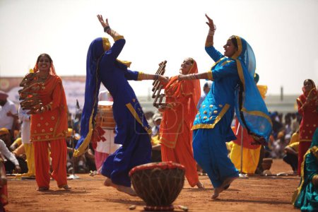 Foto de Jóvenes sikh haciendo danza folclórica Giddha durante eventos culturales celebrados para celebraciones de 300 años de consagración del Guru perpetuo Granth Sahib, Nanded, Maharashtra, India - Imagen libre de derechos