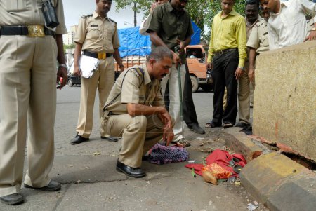 Téléchargez les photos : Le personnel de la police examine un colis non identifié pour une bombe brute présumée près de la station Chinchpokli à Bombay Mumbai, Maharashtra, Inde - en image libre de droit