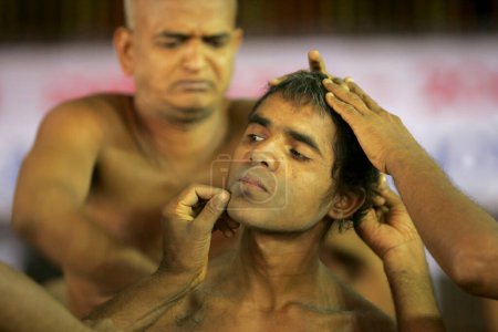 Téléchargez les photos : Sâdhu nu rasant les cheveux de la personne qui prend Deeksha, cérémonie d'initiation pour devenir moine au festival Mahamastakabhisheka Jain, Shravanabelagola, district de Hassan, État du Karnataka, Inde - en image libre de droit