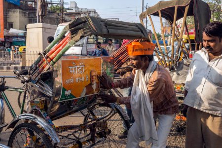 Foto de Hombre pegando cartel en ciclo rickshaw Varanasi uttar pradesh india Asia - Imagen libre de derechos