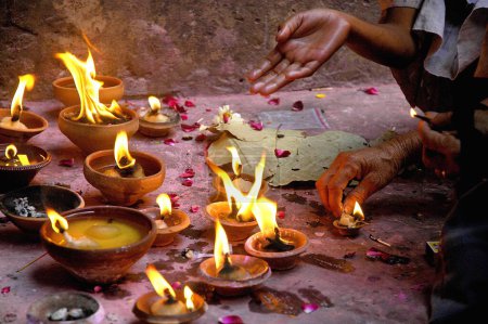 Téléchargez les photos : Prier avec des lampes à huile allumées diyas ; Banke Bihari Temple ; Mathura ; Uttar Pradesh ; Inde - en image libre de droit