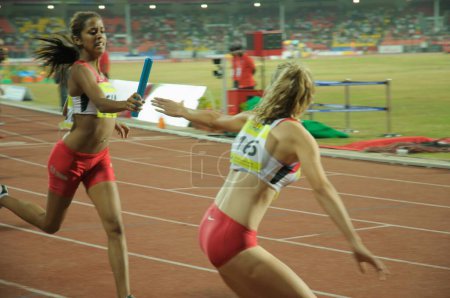 Foto de Atleta extranjero pasando batuta a otro atleta; Pune; Maharashtra; India 16-octubre-2008 NOMR - Imagen libre de derechos