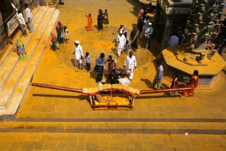 Téléchargez les photos : Les dévots rendant hommage au palanquin du seigneur Khandoba plongé dans la poudre de curcuma, temple Jejuri, Pune, Phaltan, Maharashtra, Inde - en image libre de droit