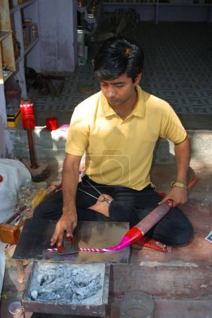 Téléchargez les photos : Homme chauffant la cire pour bracelets ; Jodhpur ; Rajasthan ; Inde - en image libre de droit