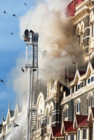 Photo for Fire fighters try to douse fire of Taj Mahal hotel terrorist attack by deccan mujahedeen on 26th November 2008 in Bombay Mumbai, Maharashtra, India - Royalty Free Image
