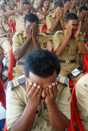Téléchargez les photos : Les policiers de Mumbai pratiquent des techniques de méditation pour soulager leur stress dans un camp à Bombay maintenant Mumbai. Maharashtra. Inde - en image libre de droit
