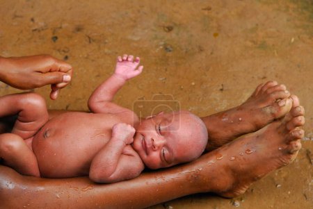 Téléchargez les photos : Tribus Ho mère baignant bébé. Chakradharpur. Jharkhand. Inde - en image libre de droit