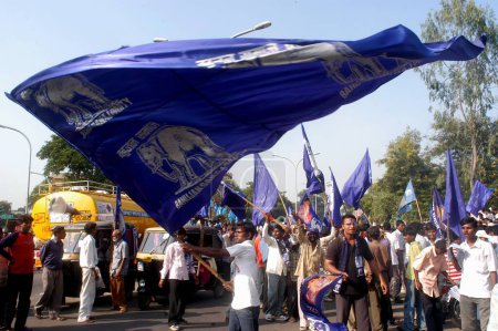 Foto de Un hombre ondea la bandera del Partido Bahujan Samajwadi (BSP) durante un mitin del presidente del partido Mayawati durante la campaña electoral para las elecciones de 2004 en Nagpur, Maharashtra, India - Imagen libre de derechos