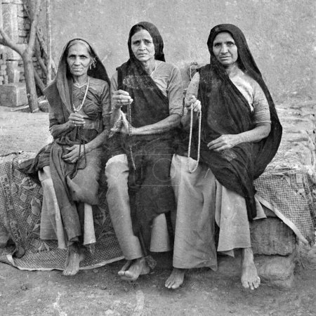 Foto de Viejo vintage 1900 en blanco y negro imagen de tres mujeres de la aldea india cantando cuentas japamala India 1940 - Imagen libre de derechos