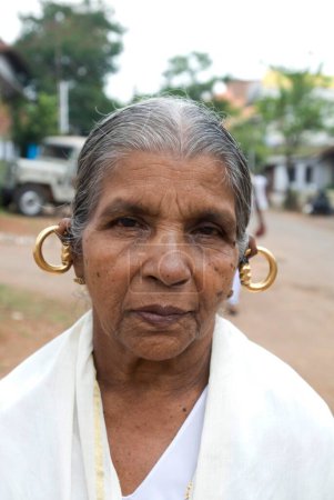 Téléchargez les photos : Boucles d'oreilles rondes Kunnukku portées par la vieille dame syrienne traditionnelle. Kerala. Inde - en image libre de droit