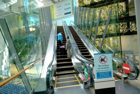 Foto de Interior de la terminal del aeropuerto y escaleras mecánicas, Singapur - Imagen libre de derechos