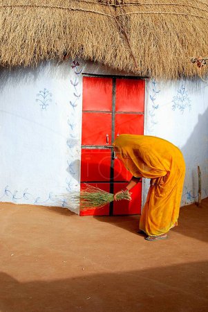 Photo for Woman cleaning hut ; Bikaner ; Rajasthan ; India - Royalty Free Image