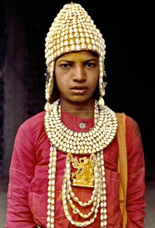 Téléchargez les photos : Un jeune gondhali vêtu d'une robe traditionnelle au festival Khandoba. Ils chantent des chansons à la louange de Khandoba et gagnent leur vie par des offrandes de dévots, Jejuri, Maharashtra, Inde - en image libre de droit