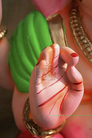 Photo for The painted right palm against a green coloured part of the shoulder of the idol of Lord Ganesh ; Pune ; Maharashtra ; India - Royalty Free Image