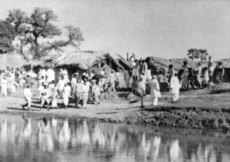 Téléchargez les photos : Les gens marchant le long d'une rivière dans la zone touchée par les émeutes de Noakhali East Bengal, novembre 1946, Inde - en image libre de droit