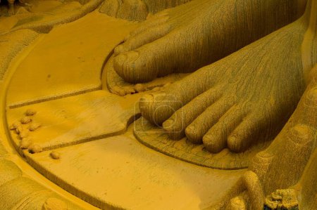 Photo for Foot of  58.8 feet monolithic full length statue of jain saint Gomateshwara lord Bahubali covered in turmeric powder in Mahamastakabhisheka head anointing ceremony; Sravanabelagola ; Karnataka ; India - Royalty Free Image