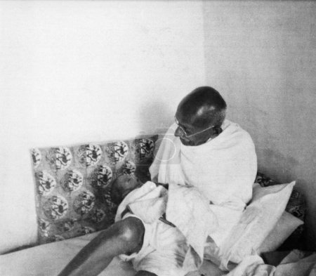Foto de Mahatma Gandhi levantándose del descanso durante su visita a la zona afectada por los disturbios de Noakhali en Bengala Oriental, noviembre de 1946, India - Imagen libre de derechos