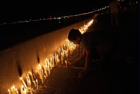 Foto de Personas encendiendo velas en la unidad marina rindiendo homenaje a las víctimas de ataques terroristas por muyahidines decanos; Bombay Mumbai; Maharashtra; India 30-noviembre-2008 - Imagen libre de derechos