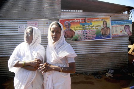 Téléchargez les photos : Two jain sadhavis and posters, during Mastakabhishek which happens after every 12 years, Shravanbelgola, Karnataka, India - en image libre de droit