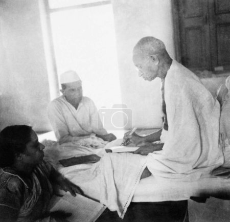 Photo for Mahatma Gandhi just after breaking his fast at Rashtriyashala Ashram, Rajkot, March 1939 Next to Mahatma Gandhi Jamnadas Gandhi, India - Royalty Free Image