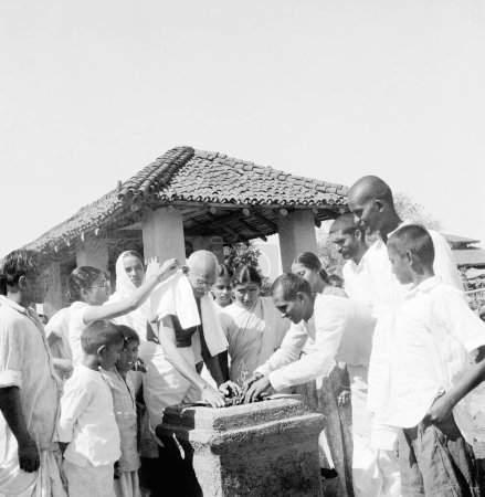 Foto de Mahatma Gandhi planta un árbol tulsi en el Ashram Sevagram, 1946, c Durga Mehta, 2º l de Mahatma Gandhi Abha Gandhi - Imagen libre de derechos