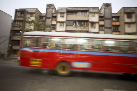 Foto de Red Best Bus passing near at building street scene in Mira road, Bombay Mumbai, Maharashtra, India - Imagen libre de derechos