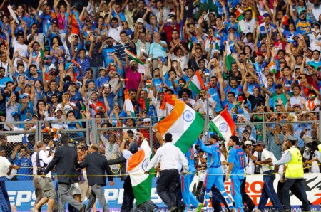 Téléchargez les photos : Le batteur indien Sachin Tendulkar est porté sur les épaules par ses coéquipiers alors qu'il agite le tricolore après que l'Inde a vaincu le Sri Lanka lors de la finale de la Coupe du monde de cricket 2011 de l'ICC jouée au stade Wankhede à Mumbai en Inde le 2 avril 2011 - en image libre de droit