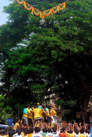 Téléchargez les photos : Pyramide humaine essayant de briser dahi handi sur janmashtami festival à dadar, Bombay, Mumbai, Maharashtra, Inde - en image libre de droit