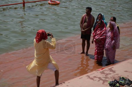 Photo for Man clicking photo of family shipra river, Ujjain, Madhya pradesh, India, Asia - Royalty Free Image