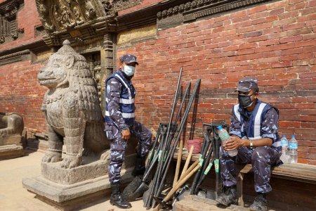 Téléchargez les photos : Le personnel de la police prend une pause, temple krishna, nepal, asie - en image libre de droit