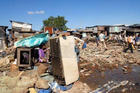 Foto de Habitantes de barrios marginales se sientan con sus pertenencias después de la demolición de barrios marginales en el aeropuerto de Sahar Aeropuerto Internacional de Chatrapati Shivaji en Bombay Mumbai, Maharashtra, India - Imagen libre de derechos
