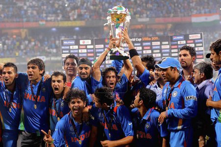 Téléchargez les photos : Les joueurs de cricket indiens célèbrent avec le trophée de la Coupe du monde ICC après avoir battu le Sri Lanka dans le match final de la Coupe du monde de cricket 2011 de l'ICC au stade Wankhede à Mumbai le 2 avril 2011. - en image libre de droit