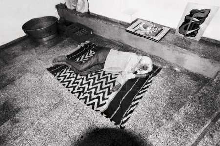Téléchargez les photos : M F Hussain dormir dans la galerie sur tapis Inde Asie - en image libre de droit