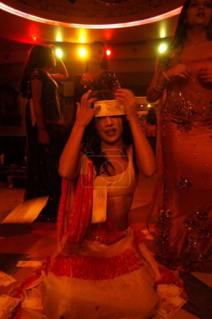 Téléchargez les photos : Douche d'argent sur les filles décorées dansant dans le bar, Bombay Mumbai, Maharashtra, Inde - en image libre de droit