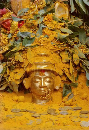 Photo for The bust of Malshabai, Khandobas wife, is showered with turmeric powder, leaves, flowers and coins by the devotees, Jejuri, Maharashtra, India - Royalty Free Image