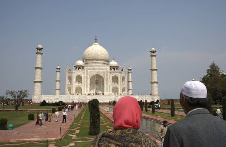 Photo for Kashmiri couple viewing at Taj Mahal Seventh Wonders of World on the south bank of Yamuna river , Agra , Uttar Pradesh , India UNESCO World Heritage Site - Royalty Free Image