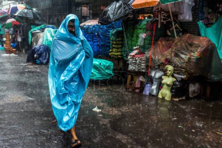Téléchargez les photos : Homme couvert de feuille de plastique saison des pluies, dalhousie, kolkata, ouest du Bengale, Inde, Asie - en image libre de droit