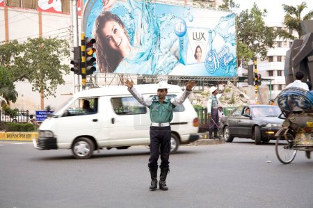 Téléchargez les photos : Scène de rue, police de la circulation contrôlant la circulation sur la thésaurisation de rue de l'actrice populaire indienne Ashwarya Rai en arrière-plan, Dhaka, Bangladesh - en image libre de droit