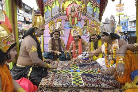 Téléchargez les photos : Janmashtami festival ou Lord Krishna anniversaire célébration carnaval procession avec diverses scènes de Mahabharat épique représentant jeu comme les échecs joué par des modèles déguisés en Kauravas et Pandavas, Jabalpur, Madhya Pradesh, Inde - en image libre de droit