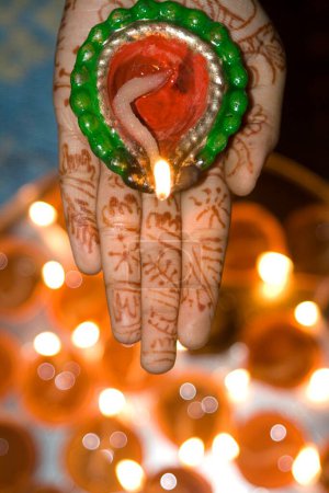 Photo for Woman holding diya dip dipak oil lamp on hand , Mehandi Heena pattern , Diwali deepawali festival , India - Royalty Free Image