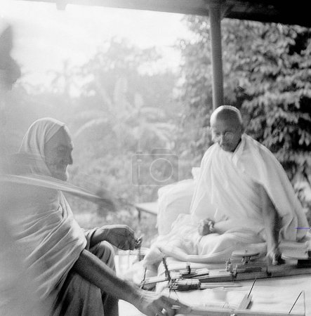 Téléchargez les photos : Khan Abdul Gaffar Khan et Mahatma Gandhi parlent de la philosophie de filature à Khadi Pratishthan ; Sodepur ; 24 Parganas ; Calcutta ; 1946 ; Inde - en image libre de droit