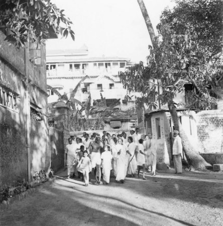 Foto de Mahatma Gandhi y otros caminando en el complejo de Birla House después de completar la oración en Rungta House; Mumbai; 1945; India - Imagen libre de derechos