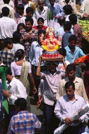 Téléchargez les photos : Homme prenant idole sur son front pour Ganesh ganpati Festival tête d'éléphant Lord procession, dadar, bomay mumbai, maharashtra, Inde - en image libre de droit