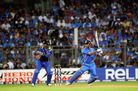 Photo for Indian captain, batsman M S Dhoni plays his shot watched by Sri Lankan captain, wicketkeeper Sangakkara during the 2011 ICC World Cup Final between India and Sri Lanka at Wankhede Stadium on April 2 2011 in Mumbai India - Royalty Free Image