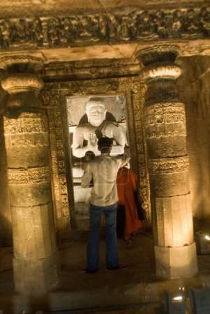 Photo for Tourists watching statue of god Buddha in Ajanta caves, Aurangabad, Maharashtra, India - Royalty Free Image