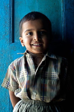 Téléchargez les photos : Enfant indien sur fond de portes en bois - en image libre de droit