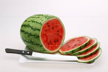 Fruits , Water Melon Latin Citrullus Lanatus slices and knife on a tray