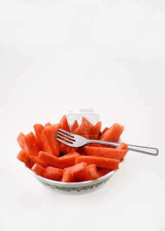 Foto de Frutas, sandía Latina Citrullus Lanatus trozos cortados en tazón con tenedor - Imagen libre de derechos