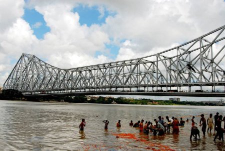 Téléchargez les photos : Personnes pendant le bain sacré sur la rivière Ganga au pont Howrah ; Calcutta ; Bengale occidental ; Inde - en image libre de droit